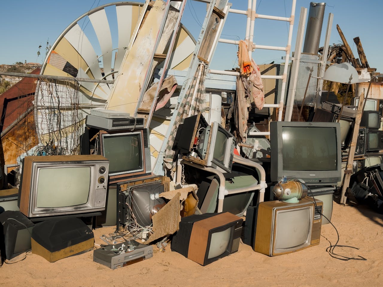 Home A pile of vintage televisions and scrap metal in the Joshua Tree desert.