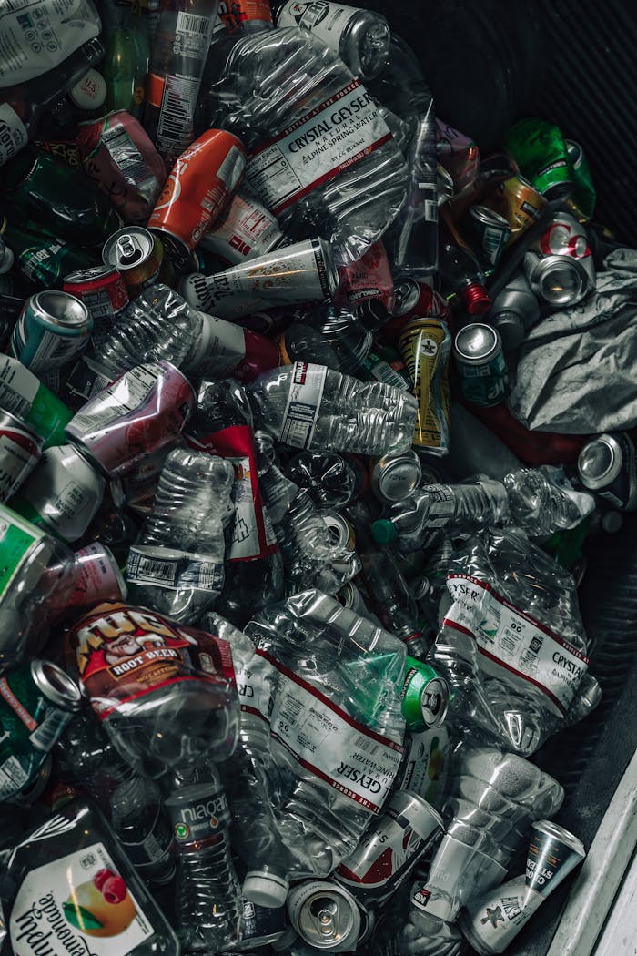 Services A vertical shot of a pile of recyclable plastic and metal containers in a recycling bin, emphasizing sustainability.